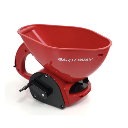 Un épandeur manuel compact de la marque "Earthway", présenté en rouge vif avec une poignée ergonomique intégrée. Le design moderne et léger le rend idéal pour épandre de petites quantités de graines, d'engrais ou de sel. L'appareil dispose d'une base noire avec un mécanisme de contrôle pour ajuster l'épandage.
